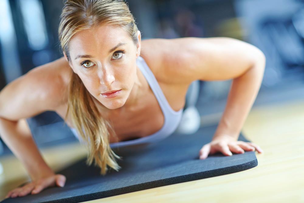 Woman doing pushups on yoga mat